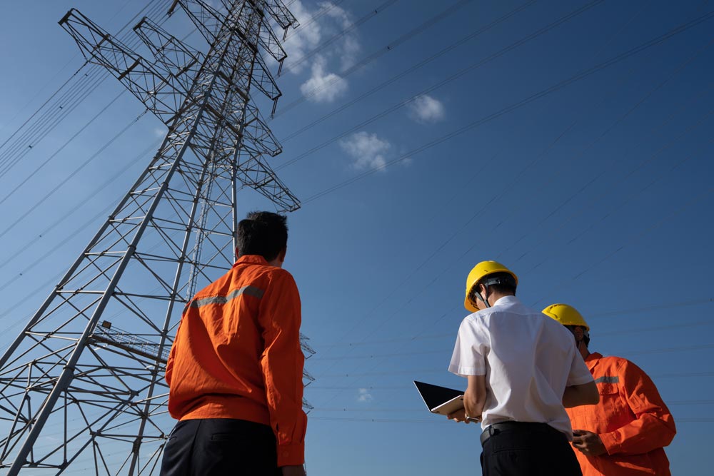 Kollegor som står vid ett elkraftnätverk